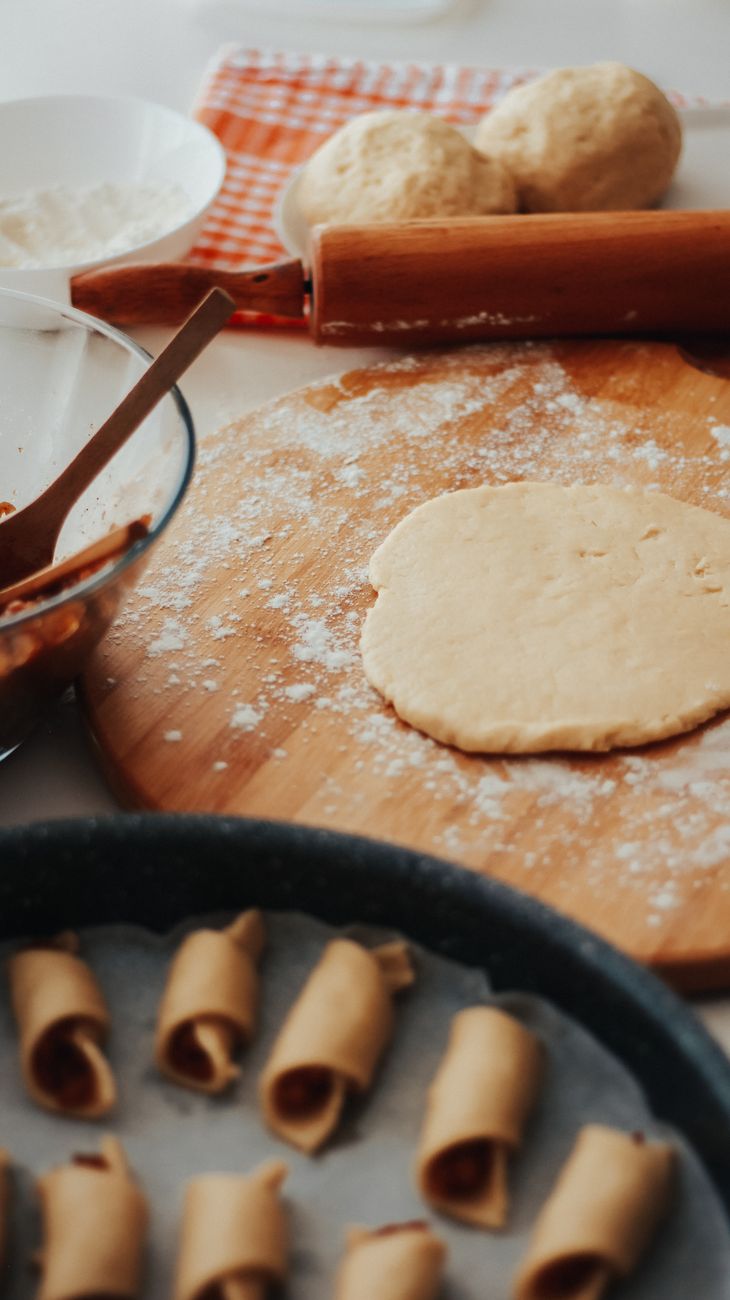 close up of raw cake dough and rolls lying on a baking tray
